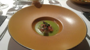 A green soup served in a bowl with a large orange rim