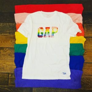 A LGBTQi themed gap t-shirt. A white shirt featuring the gap logo rendered in rainbow colors.